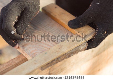 marking boards in black gloves with a wooden corner