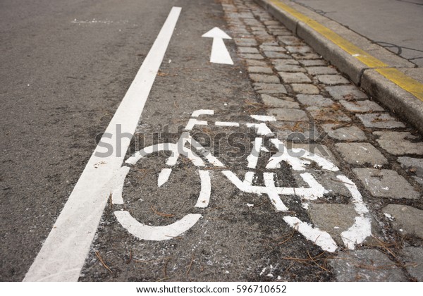 Marking on\
a one-way street with contraflow bicycle traffic in Vienna,\
Austria. Small lane allowing just bikes to enter in the opposite\
direction. Bike icon, dividing line and\
arrow.