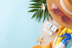Marking Summer Days: Overhead View Of June Calendar, Straw Hat, Pink Sunglasses, Sunscreen Bottle, Tropical Leaves, And Seashells On Sandy And Light Blue Background With Space For Notes