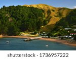 The Marlborough Sounds in New Zealand, South Island. French Pass in the evening with some houses, boats and a landing place.