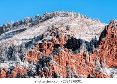 Maroon Bells area in Aspen, Colorado with closeup of orange rocky mountain cliff covered in snow after winter frozen in autumn 2019