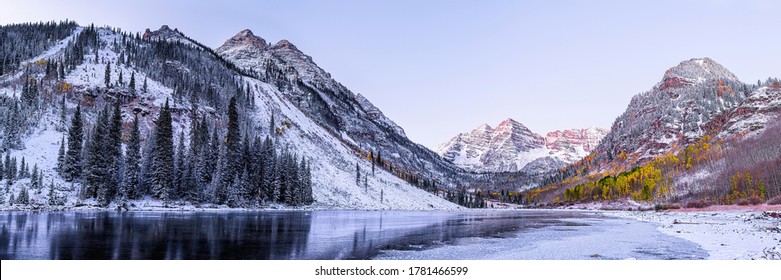 Maroon Bells morning sunrise panorama with sunlight on peak in Aspen, Colorado rocky mountain and autumn yellow foliage panoramic view winter snow