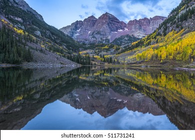 Maroon Bells Mountain Peaks Are Reflected In The Water As The Peaks Are Highlighted With Sun At Dawn In Colorado.