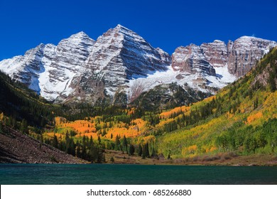 Maroon Bells on a peaceful and beautiful Autumn day. With Snow covered mountains.