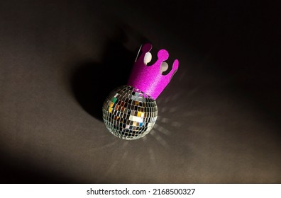 Maroon And Pink Crown With Silver Shining Party Ball On Black Background