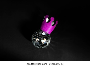 Maroon And Pink Crown With Silver Shining Party Ball On Black Background