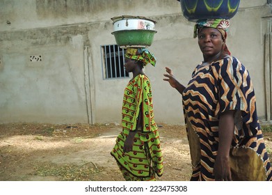 MAROUA,CAMEROON - CIRCA MAY 2008 -  Cameroonian woman in traditional dresses carrying their luggage on their heads , Maroua, Cameroon