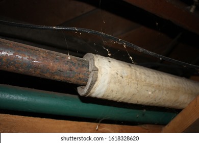 Marquette, MI / USA - April 27, 2010:  Wrap Style Asbestos Pipe Insulation On Heat Pipes From Boiler System In Basement Of Home.