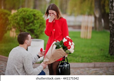 Marriage Proposal. Man With Boquet Of Flowers Kneeling And Give Engagement Ring For His Girlfriend