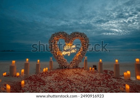 Marriage proposal setup on beach in the Maldives at sunset with red roses, flowers and candle lights. Will You Marry Me Sign and decoration 