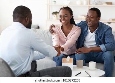 Marriage Reconciliation. Happy Black Couple Grateful To Family Counselor After Successful Therapy, Shaking Hands With Therapist At Office
