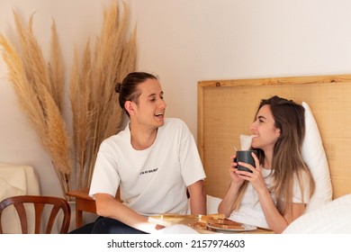 Marriage Of Young Man And Woman Having Breakfast In Bed While Laughing And Talking For A While