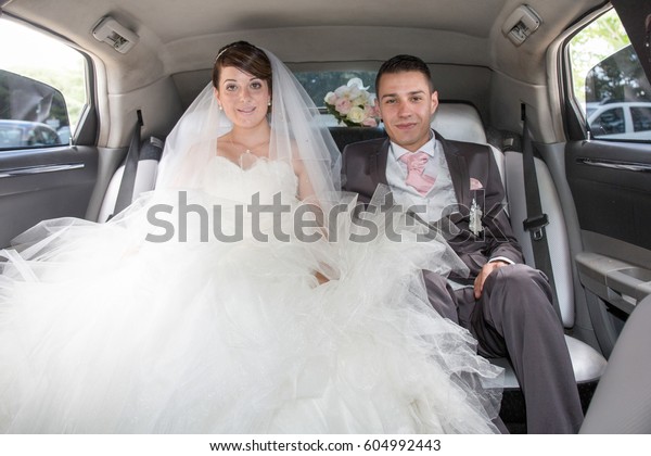 married couple in\
the big limousine wedding\
car