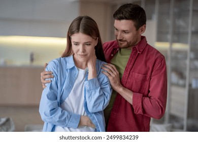 Married couple calmly solving problems in relationship. Peaceful guy husband smiles, trying to instill confidence in frustrated disappointed girl wife, calm down with presence, support, improve mood.