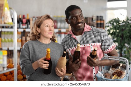 Married couple choose wine and beer together for a holiday party at a grocery store