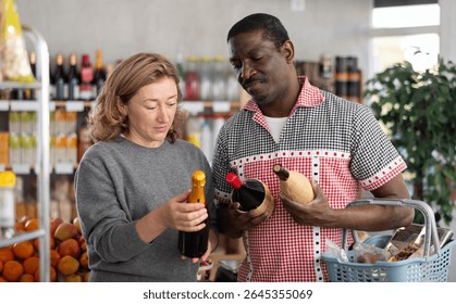 Married couple choose wine together for a holiday party at a grocery store