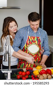 Married Couple Enjoying Their Time At Home Cooking. Man Coocking. Husband And Wife In The Kitchen At Home