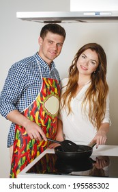 Married Couple Enjoying Their Time At Home Cooking. Man Coocking. Husband And Wife In The Kitchen At Home