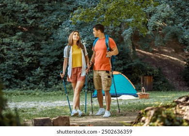 Married couple preparing to start their hiking routes. Tent is behind them and they have hiking poles and other equipment for hiking. - Powered by Shutterstock