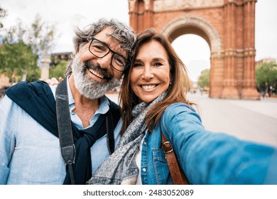 Married couple taking selfie in front of Triumphal Arch in Barcelona, Catalonia, Spain - Husband and wife enjoying romantic moment together at summer holiday in Europe - Powered by Shutterstock