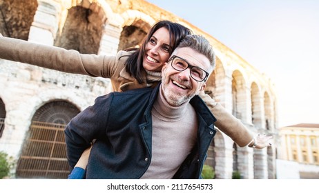 Married couple of tourists walking on city street visiting Italy - Senior man and woman enjoying weekend vacation - Happy lifestyle concept