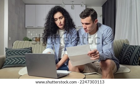 Married couple tries to figure out problems with expensive utility bills and complains about huge prices for communal services. Man and woman tries to pay bills