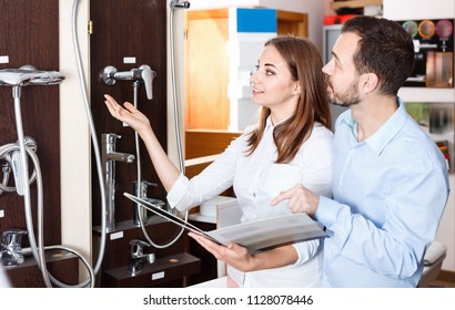 Married glad pleasant beautiful couple visiting furniture salon in search of shower mixer