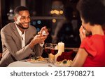 Marry me. Loving afro man proposing to girlfriend holding engagement wedding ring dating in fancy restaurant. Selective focus