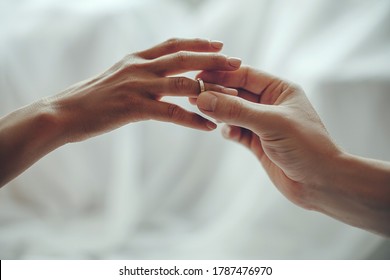 Marry me today and everyday, hands of a wedding heterosexual couple. Groom put a ring on finger of his lovely wife.
