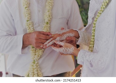 Marry me today and everyday, hands of a wedding couple. Groom put a ring on finger of his lovely wife. Bride and groom exchanging rings