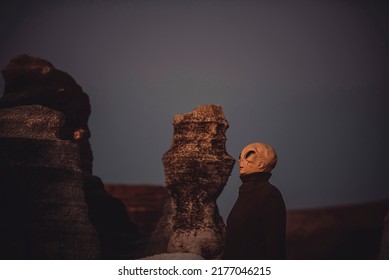 Mars and other planets life concept with standing ufo and moon landscape around. Outdoor alien mask people side portrait. Concept of diversity and extraterrestrial among us invasion