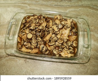 Marsala Chicken With Mushrooms In A Glass Casserole Dish.