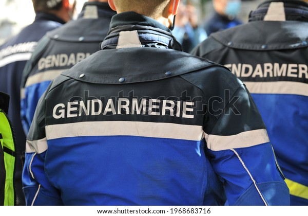 Marseille, France - March 30, 2021: a\
group of gendarmes from behind with the name Gendarmerie written in\
large letters on their uniform in the center of the\
image