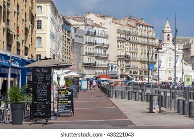 Marseille, Provence/France. July 2015. The Old Port Area Of The City With Shops, Bars And Restaurants Surrounding The Harbor. Unidentified People.