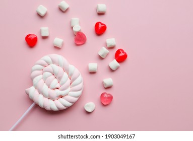 Marshmallow in heart shape with red and pink candy flat lay on pink background - Valentines day, love and romance concept