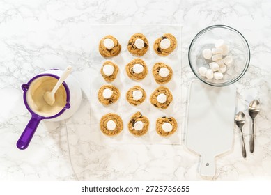 Marshmallows placed on top of Ghost Chocolate Chunk Cookies as the first step of decoration. Perfect for recipe step visuals, food tutorials, or editorial dessert photography.