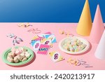 Marshmallows are served in round plates, uno cards, ribbons and cone-shaped birthday hats placed on a pink background. Close-up perspective. Copy space for ads.