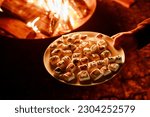Marshmellows with Halloween pictures over fire. Funny leisure on traditional spooky holiday for children and families.