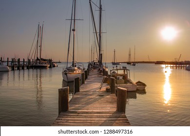 Martha's Vineyard, MA / United States-May 29, 2016: Sail Boat And Motorboat Tied Up To A Dock At Sunrise. 