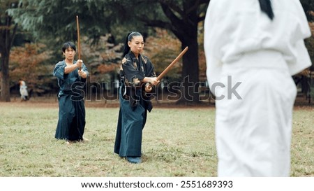 Martial arts, exercise and class instructor with wood sword for fight, battle and samurai training. Park, ninja and mentor with bamboo weapon, kendo and warrior in autumn in Japan with fighter group