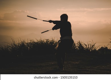 Martial Arts, nunchaku warrior silhouette, asian samurai at sunset fighting  - Powered by Shutterstock