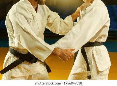 Martial Arts. Sparing Portners. Sport Man And Woman In White Kimono Train Judo Captures In The Sports Hall. Crop Photo