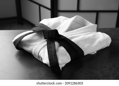 Martial arts uniform with black belt on grey stone table indoors - Powered by Shutterstock