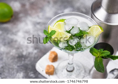 Martini cocktail with ice, lime and mint.