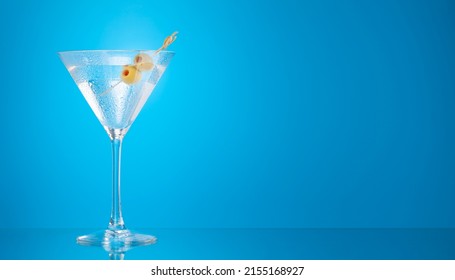 Martini cocktail on blue background with copy space