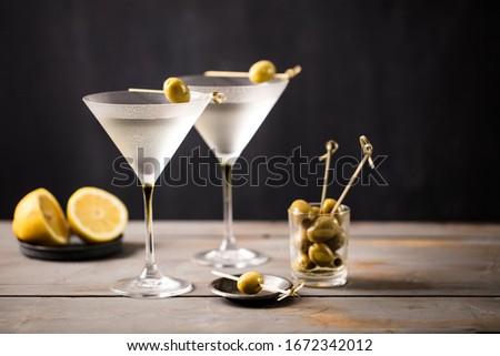 Martini cocktail on wooden worktop. Olive garnish. Space for text