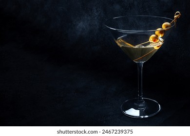 Martini. A glass of dirty martini cocktail with vermouth and olives, on a black background with a place for text - Powered by Shutterstock