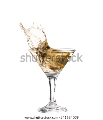 A martini glass on a white background; the water ripples and splashed as a green spanish olive with pimento is dropped into the glass; horizontal format