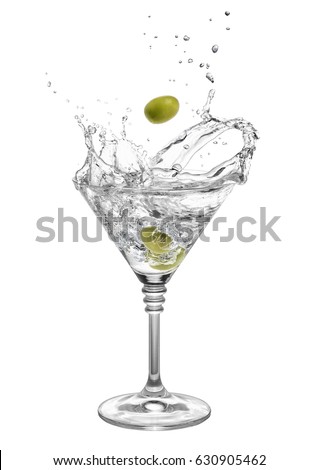 martini in glass with splashes isolated on white background. Green olive is falling in the alcohol cocktail