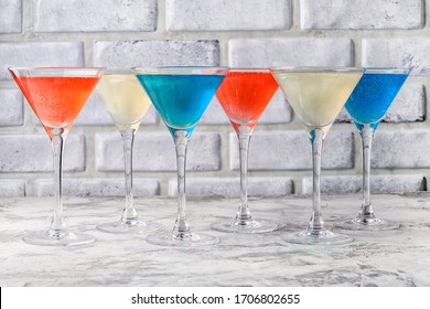 In Martini Glasses With A Brilliant Celebratory Drink. Red, Blue, White Alcoholic Drinks. Glitter Drink.